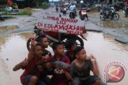 Lomba Tangkap Ikan di Kubangan Jalan Nasional