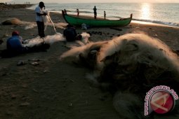 Nelayan Perbaiki Jaring Rusak