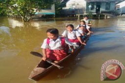 Siswa SD Ujian Nasional di Tengah Banjir