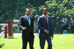 Jokowi and Li plant camphor sapling together