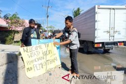 Jalan rusak, warga pasang poster "kolam pemancingan"