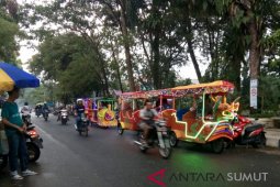 Anak-anak antre naik kendaraan hias