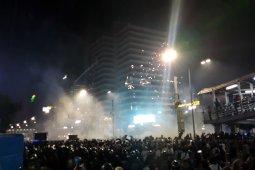 Massa di depan Gedung Bawaslu  nyalakan kembang api ke arah polisi
