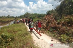 Warga Selakau gotong-royong angkut tiang listrik