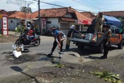 Polisi bersama warga Majalengka tambal jalan aspal berlubang