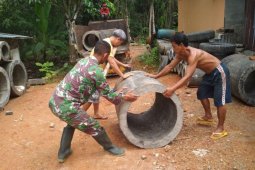 Warga dan anggota satgas TMMD dorong material gorong-gorong