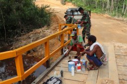 Prajurit Satgas TMMD dan warga percepat pengecatan jembatan