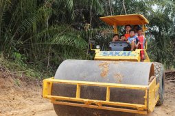Anak-anak bersuka ria bermain di alat berat terparkir