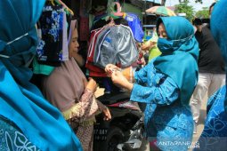 Anisah sosialisasi COVID 19 sambil bagi masker gratis
