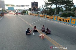 Foto - Anggota polisi lakukan pengamanan PSBB sekaligus buka puasa di jalan