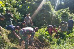 Warga dan anggota TMMD bergotong royong bersihkan Parit