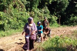 Bantu sepada motor warga melewati jalan berlumpur