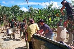 Anggota TMMD bongkar muatan mobil pengangkut material