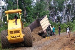 TNI dan warga gotong royong dorong truk amblas