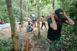 Personel TMMD dan warga gotong royong angkut pasir