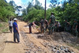 Anggota TMMD Ajak warga timbun jalan berlubang