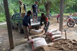 Satgas TMMD 108panggul semen ke lokasi kerja