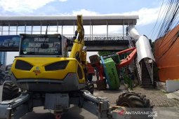 Hendak dipindahkan ke mobil pengangkut sebuat alat berat terguling timpa pagar JPO