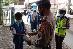 Polisi lalu lintas bagi masker kepada anak sekolah