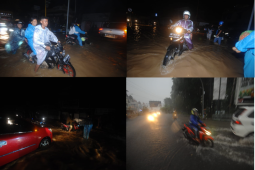 Pengendara menerobos banjir di jalan utama Kota Manado