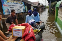 Istri Danlanud Sjamsudin Noor menembus banjir salurkan bantuan