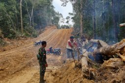 Anggota Satgas TMMD Kodim 1206/PSB bantu warga memotong kayu