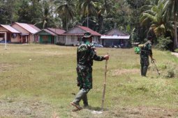 Pemuda desa dan  Satgas TMMD bersihkan lapangan desa