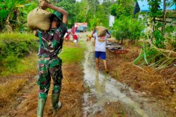 Anggota Satgas TMMD dan warga bersemboyan berat sama dipikul