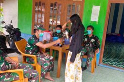 Dengan senyuman, remaja putri tuangkan kopi ke gelas Personil TMMD