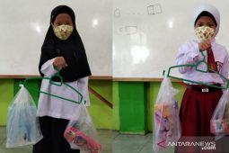 Asik belajar mengukur berat benda menggunakan gantungan baju