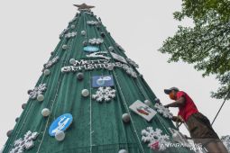 Kampanye protokol kesehatan dengan pohon Natal