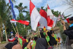 Rayakan HUT RI  anak-anak kibarkan  bendera di sepanjang Sungai  Punggur Kecil