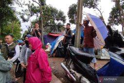 Mensos Risma menolak dipayungi oleh pengungsi saat hujan turun di Cianjur