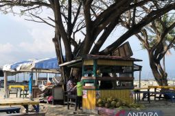Santai di pinggiran Pantai Talise dengan minuman es kelapa yang menyegarkan