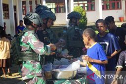 Prajurit TNI bagi bubur kancang gratis untuk anak-anak di Maybrat