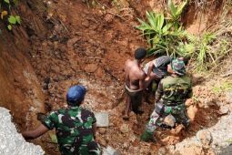Prajurit TNI bersama warga perbaiki jalan Trans Yapen-Papua yang terputus