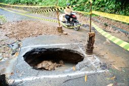 Jalan berlubang tergerus banjir