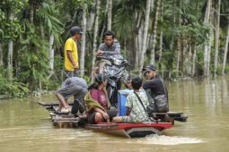 Jasa penyeberangan motor di lokasi banjir Tebo