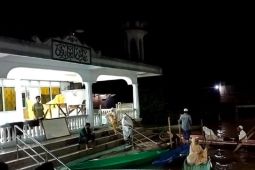 Warga berperahu menuju masjid