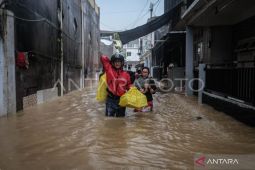Warga Manado sedang melintasi banjir