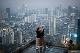 Pengunjung kagum pemandangan kota Jakarta dari gedung tertinggi