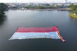 Relawan Potensi Tangsel bentangkan bendera Merah Putih di Situ Gintung
