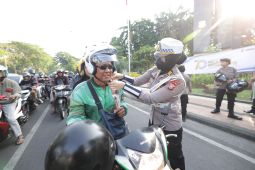 Polwan Polda Jatim "gatur lalin" sambil berbagi helm dan cokelat