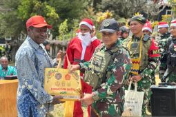 Prajurit Satgas Yonif 511/DY membagikan bapok pada perayaan Natal bagi warga Papua Pegunungan