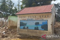 Dinding yang masih mengajar di tengah puing Garoga