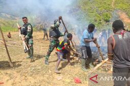 Prajurit Satgas Pamtas Yonif 511/DY bantu warga Oka Lanny Jaya bakar batu