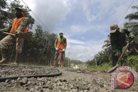 Anggota polisi tambal jalan lintas pantai timur Sumatera