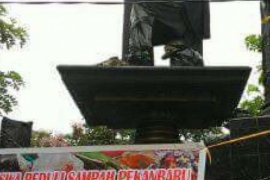 Sampah Masih Menumpuk, Tugu Adipura Pekanbaru Dibungkus Mahasiswa dengan Kain
