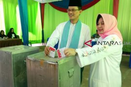Harnojoyo dan keluarga nyoblos mengenakan pakaian dominan warna putih