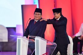 Jeda debat, Sandiaga pijat Prabowo dan Jokowi asik berfoto